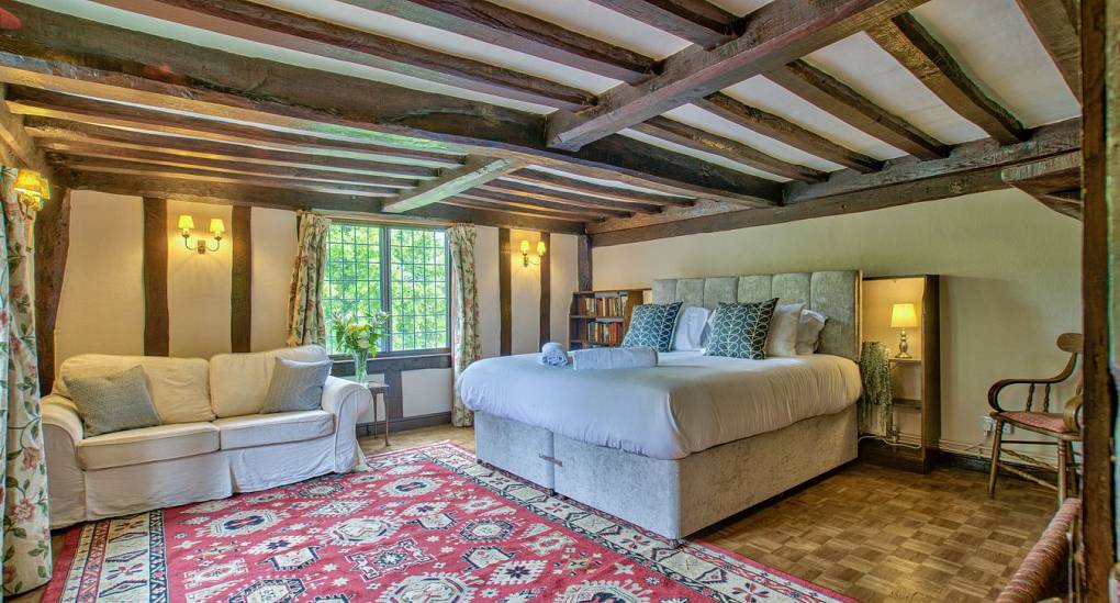 Large double bedroom with wooden beams showing