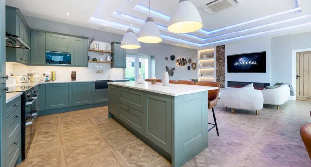 Kitchen area with standard appliances in a blue and light wood colour scheme