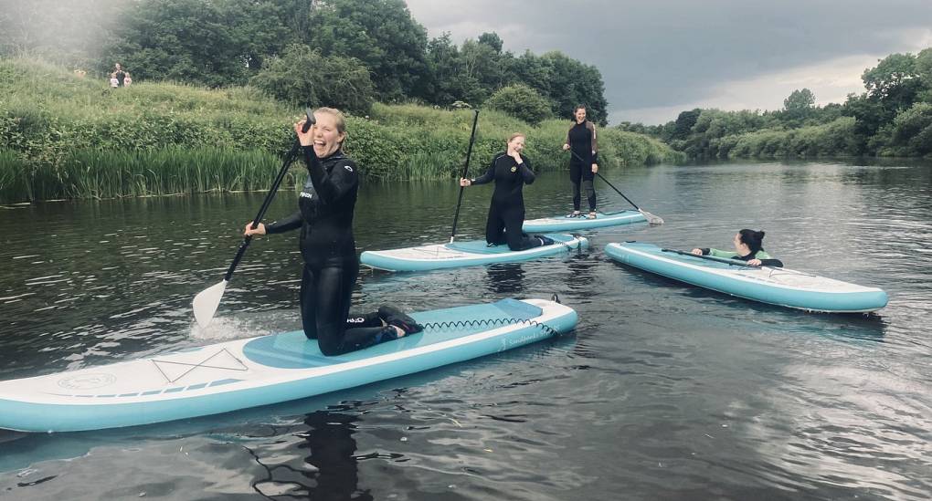 Group of hens laughing whilst paddleboarding