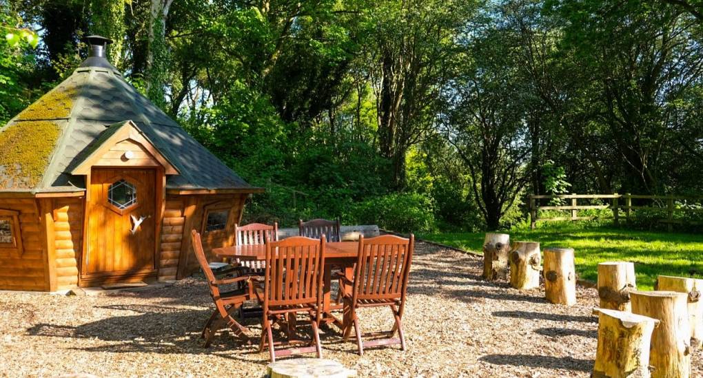 Garden area with wooden Yurt and garden furniture in the background