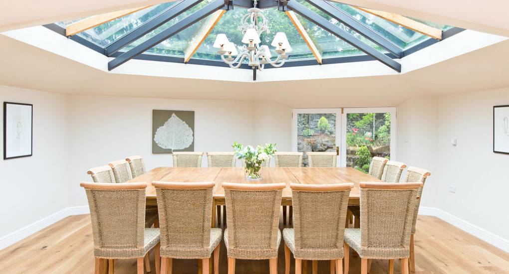 Sunken Conservatory dining hall at Peak Star with an impressive glass ceiling and seating for 24 hen party guests.