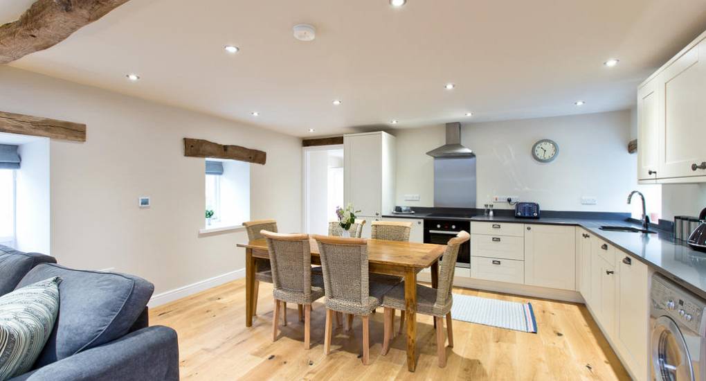 Modern farmhouse kitchen at Peak Star with original wooden ceiling beams and an open-plan layout for socialising.