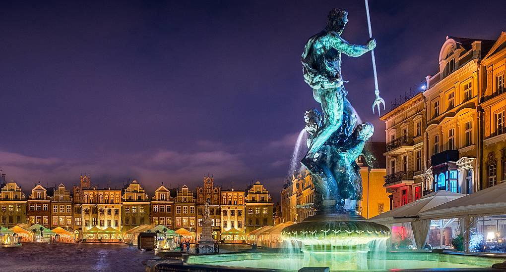 Illuminated Neptune Fountain in Poznan Old Market Square at night, atmospheric backdrop for a Poznan stag do.