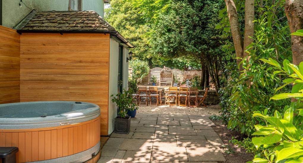 The hot tub area and decking down the secluded side of the house during daylight hours