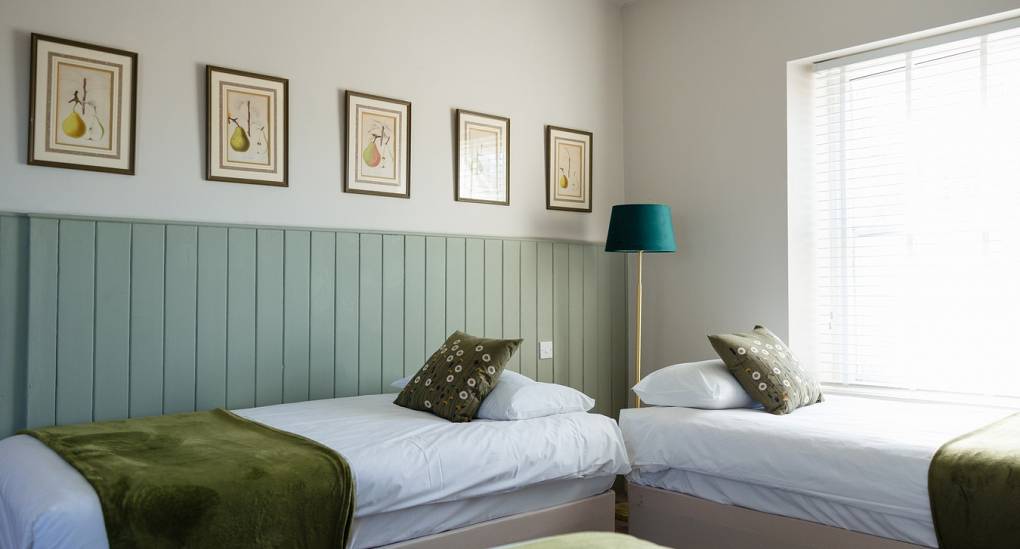 Bedroom with three single beds at the Regal Manor two luxury party house