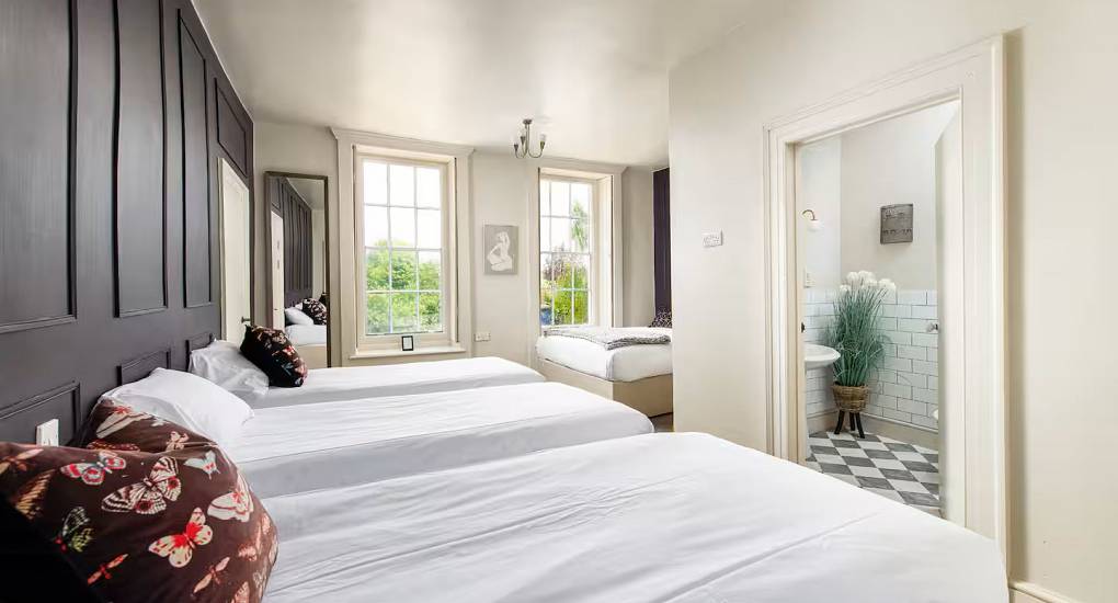 Long bedroom with plenty of beds at the Regal Manor two luxury party house