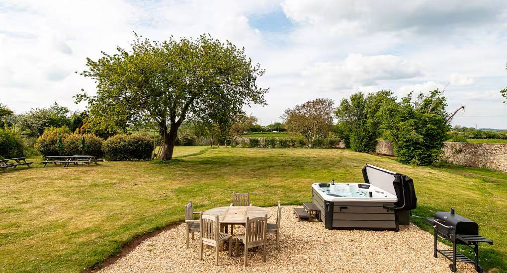 Hot tub and seating int he middle of the garden at the Regal Manor two luxury party house