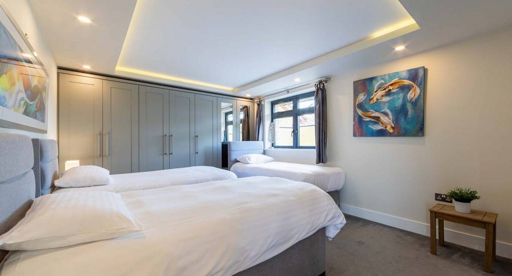 A bright and modern bedroom at Retreat 12, offering comfortable hen weekend accommodation