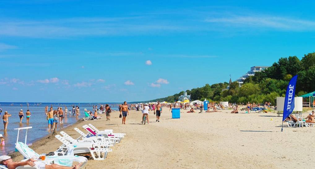 Sandy Baltic coastline and sunbed loungers on Jurmala Beach, popular coastal excursion for a Riga hen do.