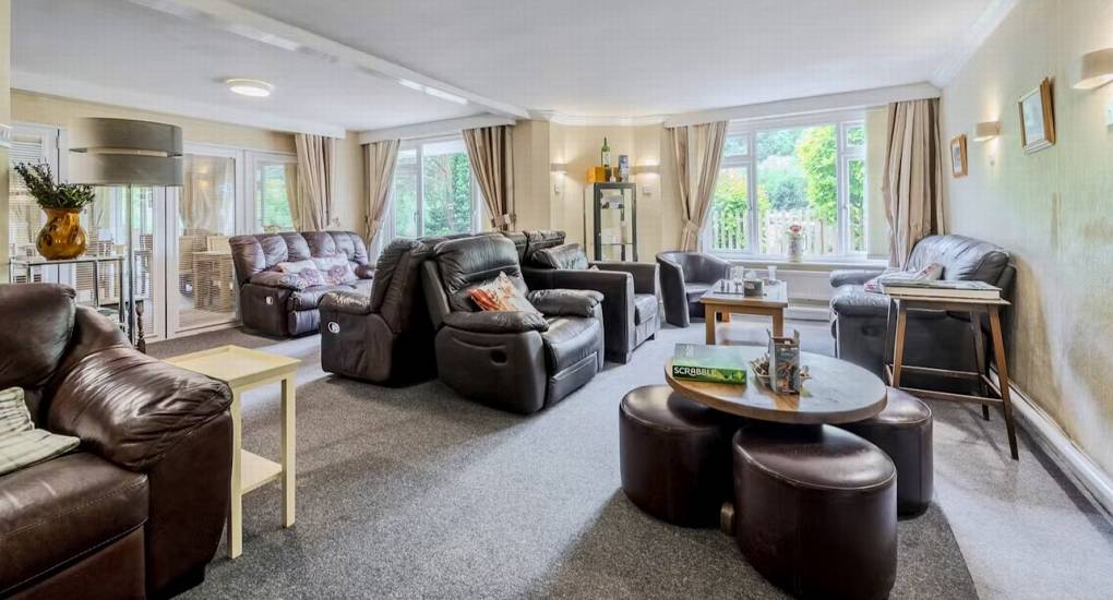 The large lounge at River View Lodge with many comfortable leather recliners, providing a spacious and relaxed communal area for a hen party.