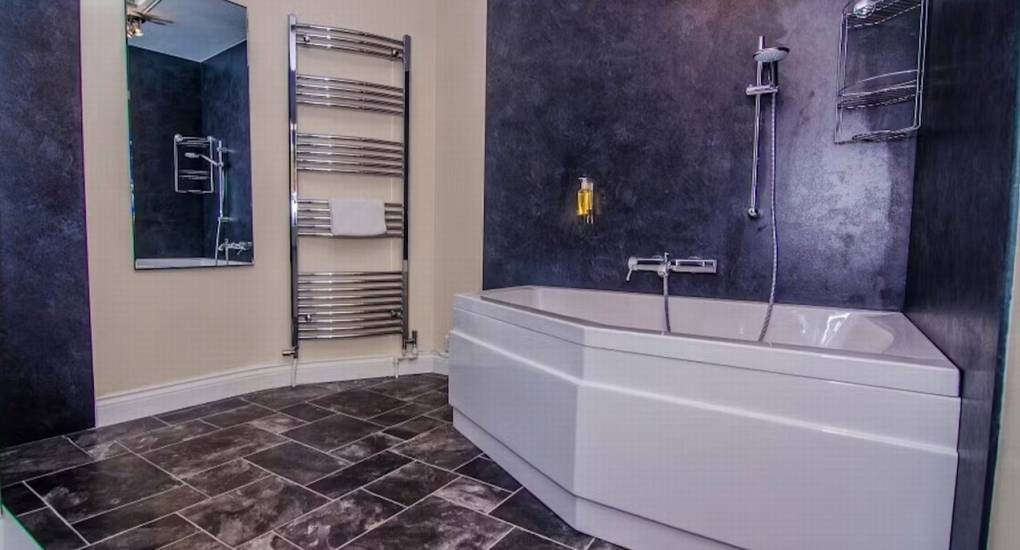 A modern en-suite bathroom at River View Lodge, featuring a spacious bathtub and walk-in shower for hen party accommodation.