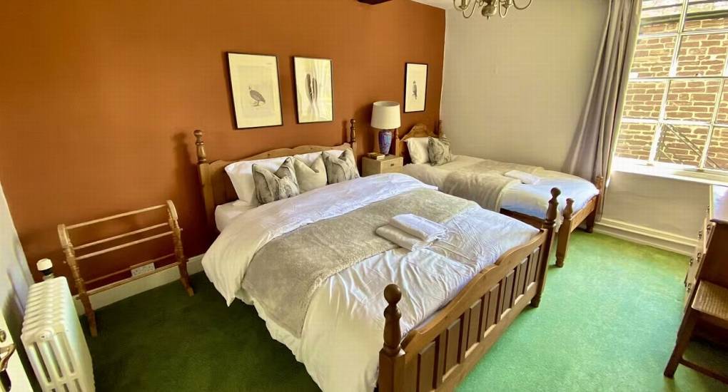 This cozy bedroom at the hen party mansion house includes a double and single bed, providing flexible sleeping arrangements for your group.