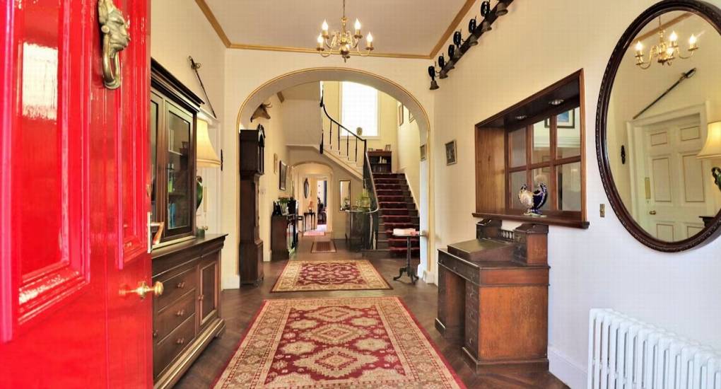 The grand entrance and hallway of Rivers Countryside Mansion, with a beautiful staircase and rustic decor for a stylish hen party.