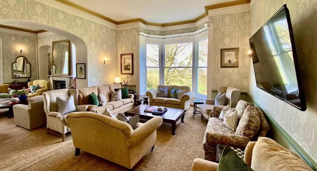 A view of the main reception room at this Herefordshire party mansion, showing the spacious seating area and large coffee tables.