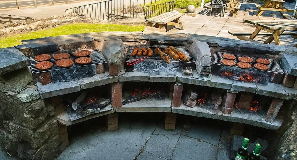 The gigantic stone BBQ area at Ross Lodge Gloucestershire, ready for outdoor cooking for the large hen do accommodation that sleeps 26.