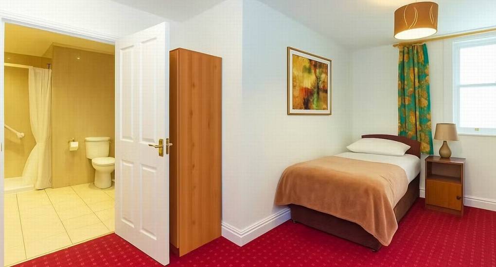 A comfortable single bedroom at Ross Lodge Gloucestershire with an en-suite bathroom, part of the flexible sleeping arrangements at this Forest of Dean hen do accommodation.