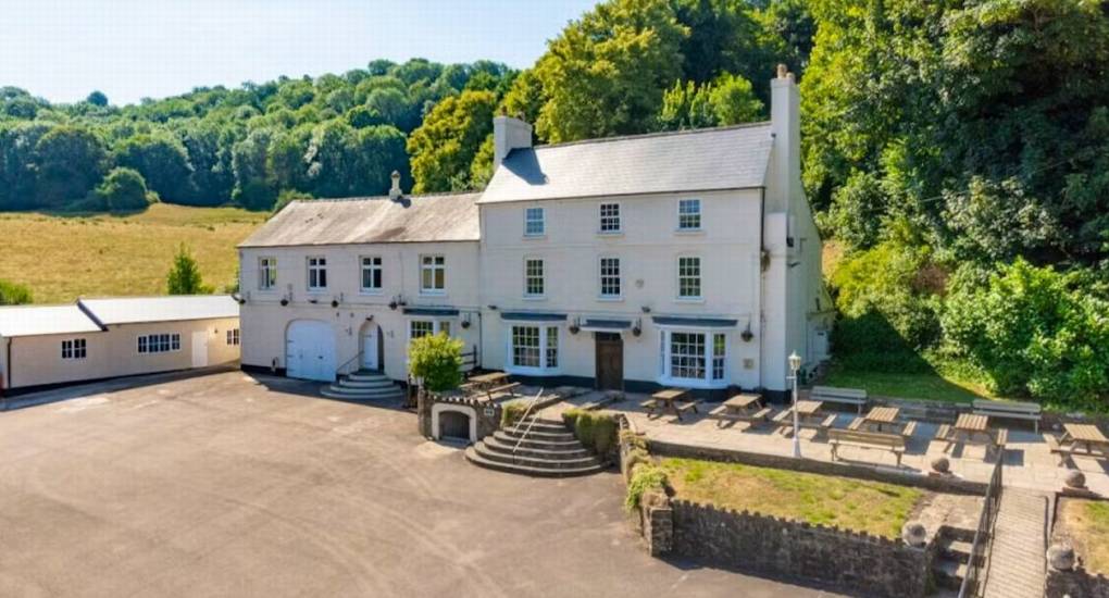 An elevated view of the large white exterior of Ross Lodge Gloucestershire surrounded by the Forest of Dean, perfect hen do accommodation that sleeps 26.