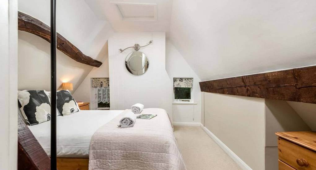 Rustic bedroom with wooden beams in the secret garden hen party house in the new forest