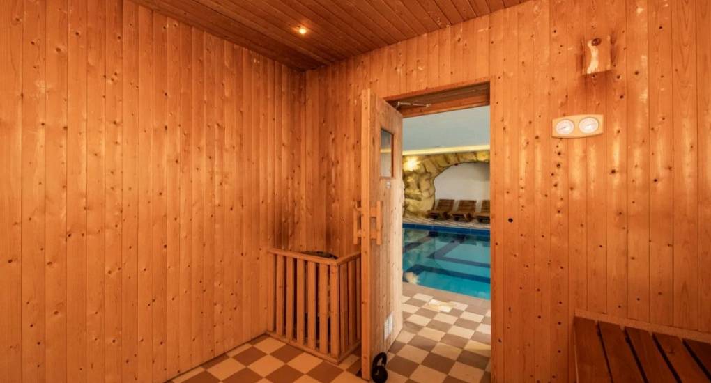 View from inside the sauna looking through the doorway to the swimming pool