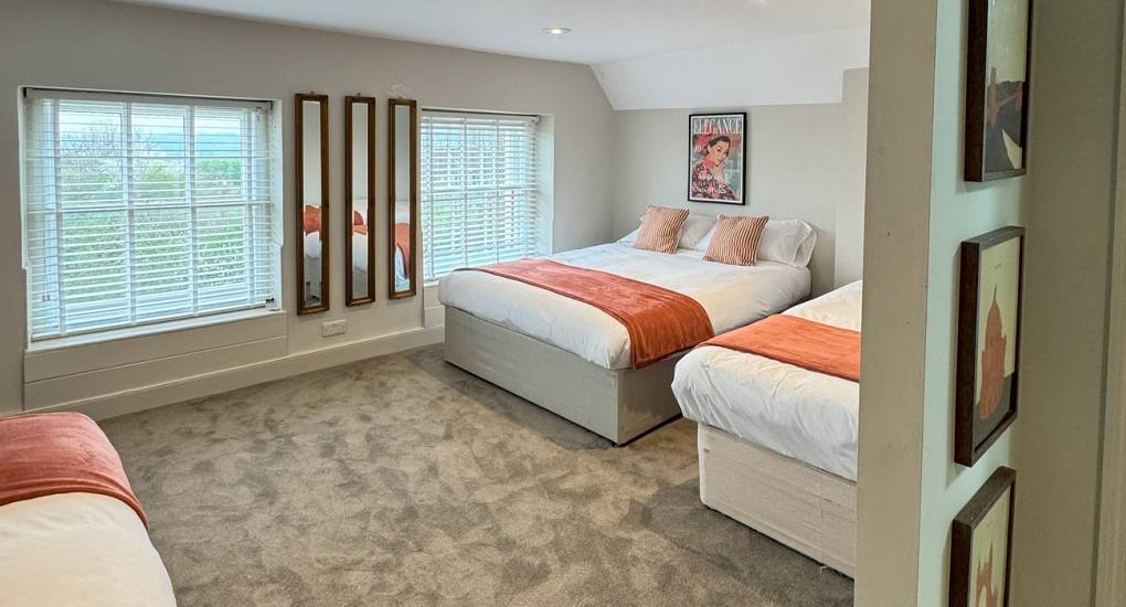 One of the nine bedrooms at the Grand Manor large party house with three made up single beds