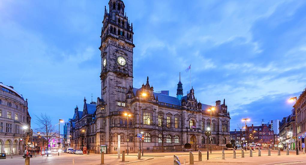 Sheffield Town Hall clock tower illuminated at twilight, historic city center backdrop for a Sheffield stag do.