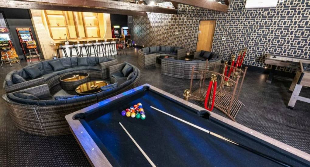 Close up of the pool table in the games room with bar in the background