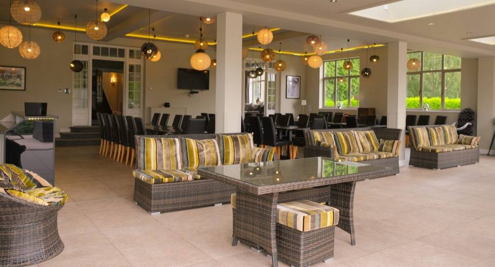 Large conservatory area with rattan style garden furniture for large groups