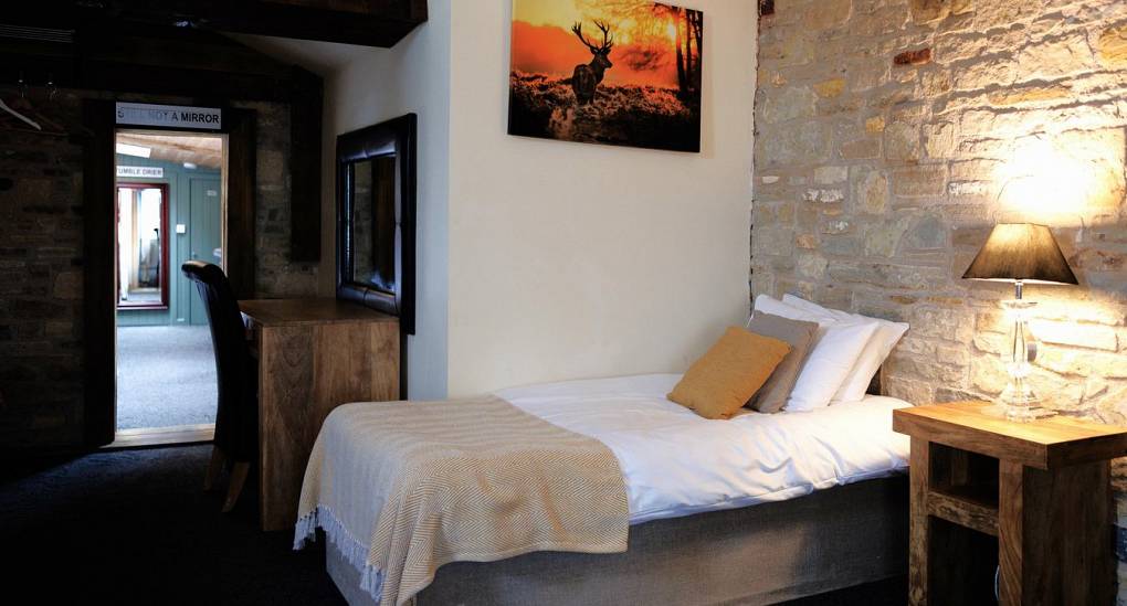 Single bed against a stone wall