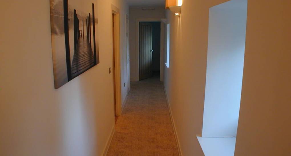 Long hallway with bathrooms and bedrooms