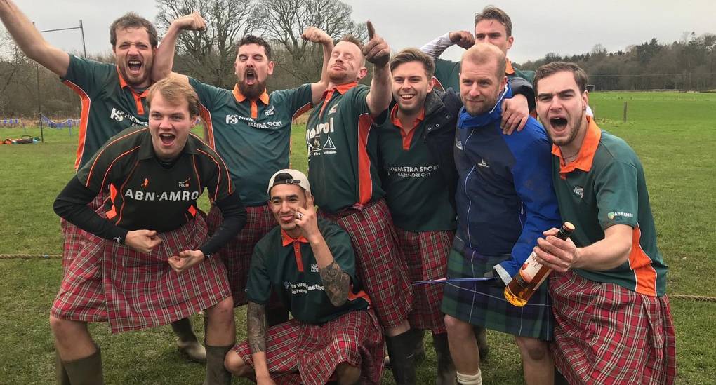 Stag do enjoying the mini highland games in fancy dress