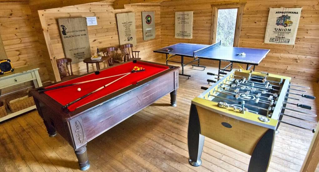 The impressive dedicated games room at Standing Barn Gloucestershire, featuring a pool table, table tennis, and table football, part of the Games Room & Hot Tub entertainment package for the party house.