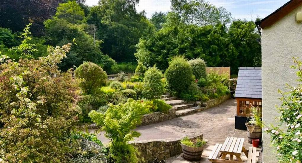 The multi-level terraced garden and patio area at Standing Barn Gloucestershire, offering beautiful views for this Gloucestershire Party House.