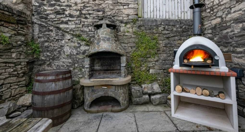 Close up of the bqq, firepit and pizza oven in the garden of the Rydal Pub party house