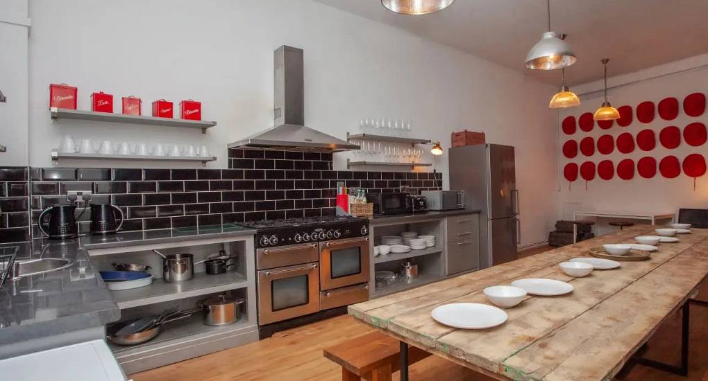 Large kitchen area and long rustic dining table at the cardiff stag accommodation, the Bunkhouse