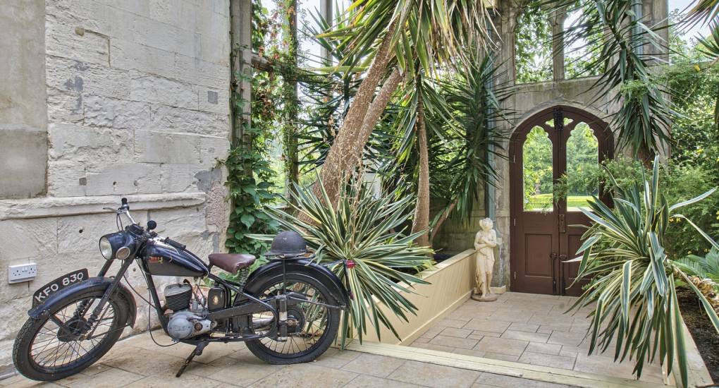 The Atrium at the Country Fortress Hen Party House with vintage motorbike in forground