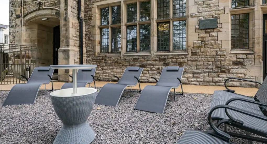Outside the property showing classic stone architecture and garden loungers