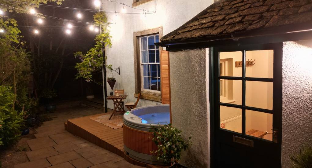 Hot tub and decking area taken at night with lighting
