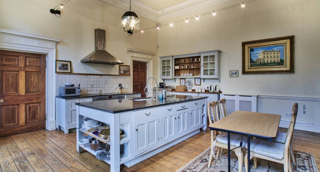 The large kitchen at the Country Fortress party house with an island and dining table