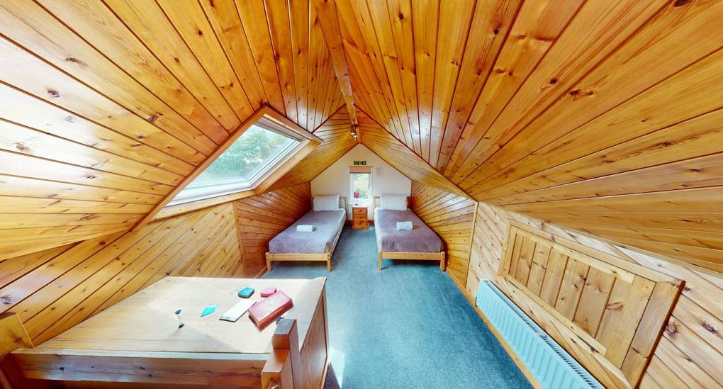 The characteristic loft room and two single beds at the Forest Tree Party House