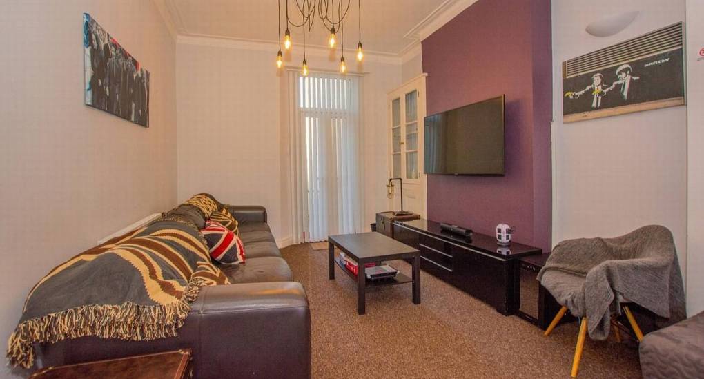 Lounge area with sofa, coffee table and wall mounted TV