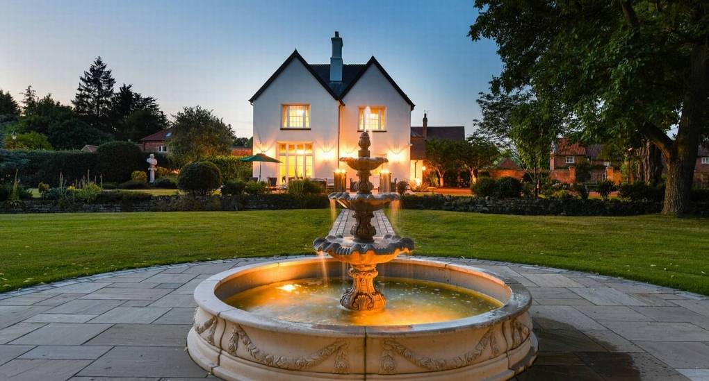 Stunning garden fountain and manor house exterior at The Parsonage, a luxury Nottingham hen party house.