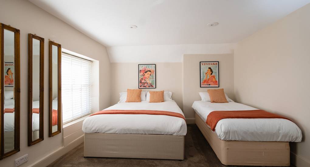 A bedroom at The Regal Manor Party House showing double and single beds