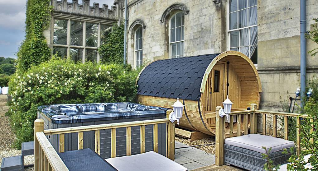 The Country Fortress party house has a sauna and hot tub with seating in a decking area