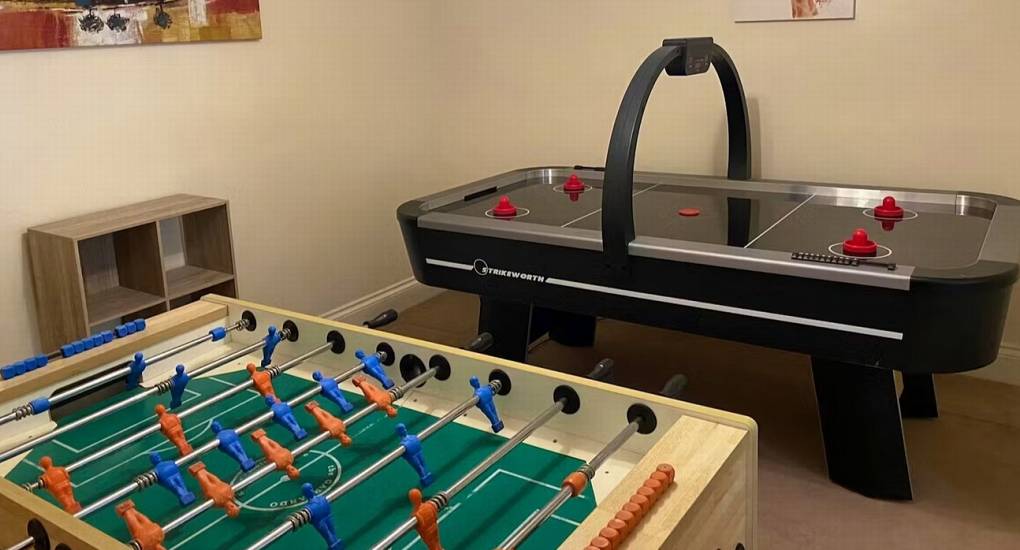 The dedicated games room at White Horse House with air hockey and table football, providing fun hen weekend accommodation for the group that sleeps 30 in Herefordshire.