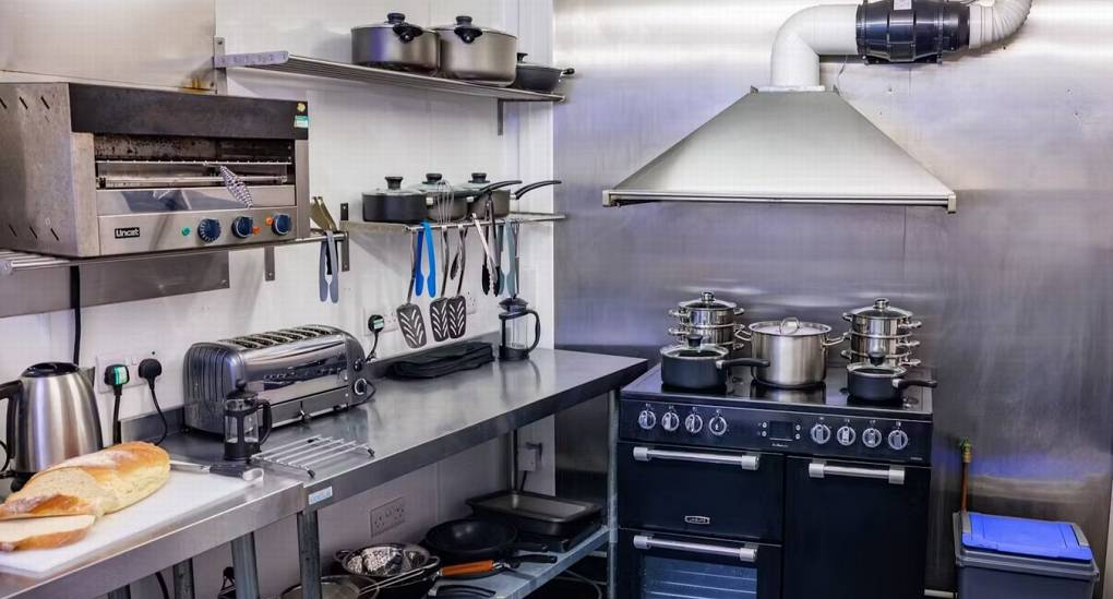 The professional catering kitchen at White Horse House, featuring a large range cooker and commercial appliances to easily self-cater for your hen weekend accommodation in Herefordshire sleeping 30.