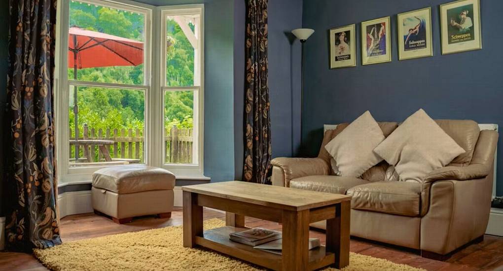 A light and airy lounge at the Wye House with blue walls and a large bay window