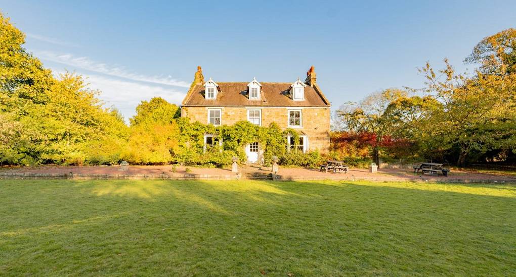 The grand front exterior and expansive private lawns at Tranquil Escape, an exclusive detached hen do house located just 15 minutes from Newcastle city centre.