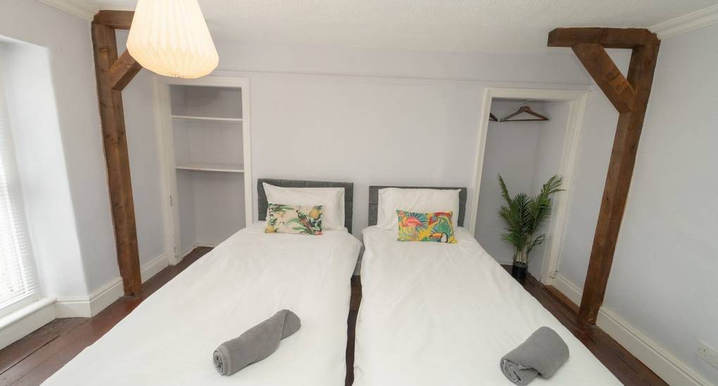 A charming twin bedroom at Tranquil Escape highlighting the traditional wooden beams and rustic character of this rural Newcastle hen do accommodation.