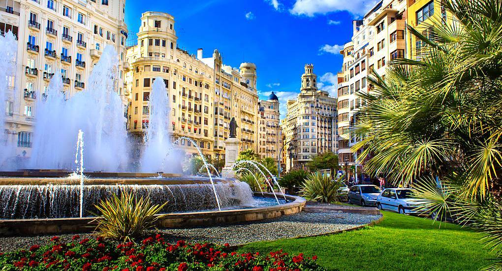 Gushing water fountain and historic square buildings in Plaza del Ayuntamiento, scenic city backdrop for a Valencia stag do.