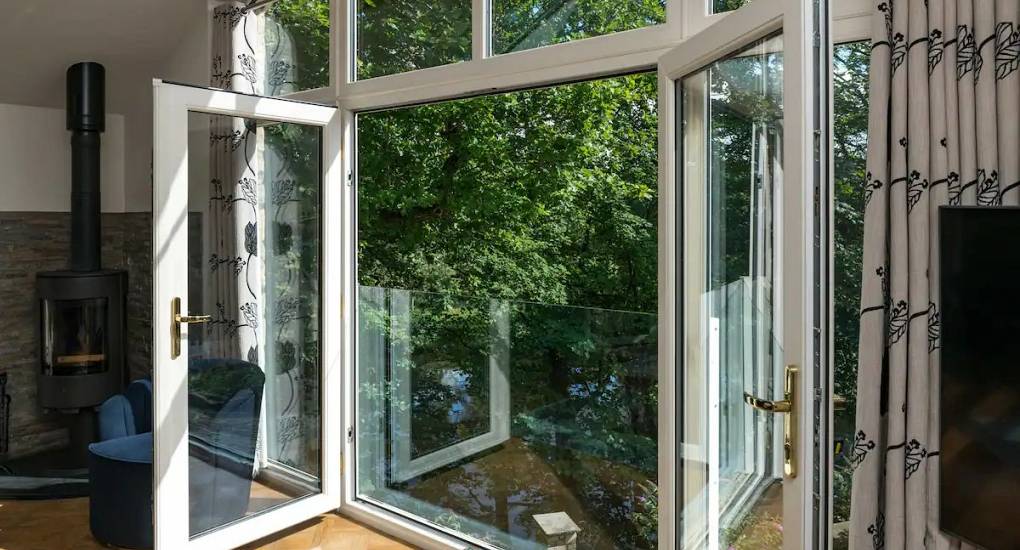 Picture of the lounge with patio doors open with foliage outside